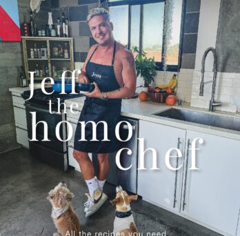 Jeff in a blue apron with two dogs.
                  