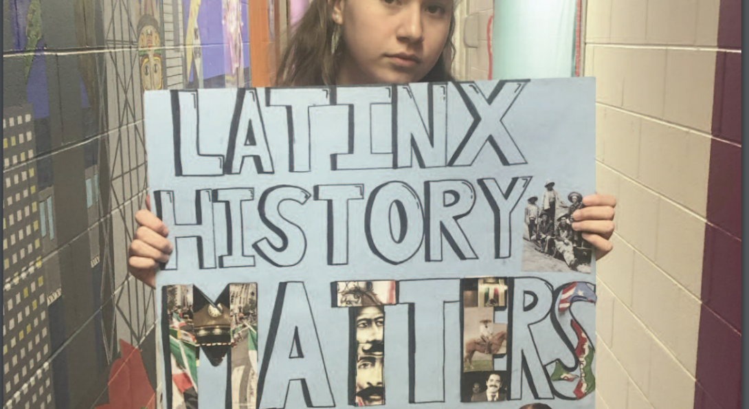 Student holding a poster reading 