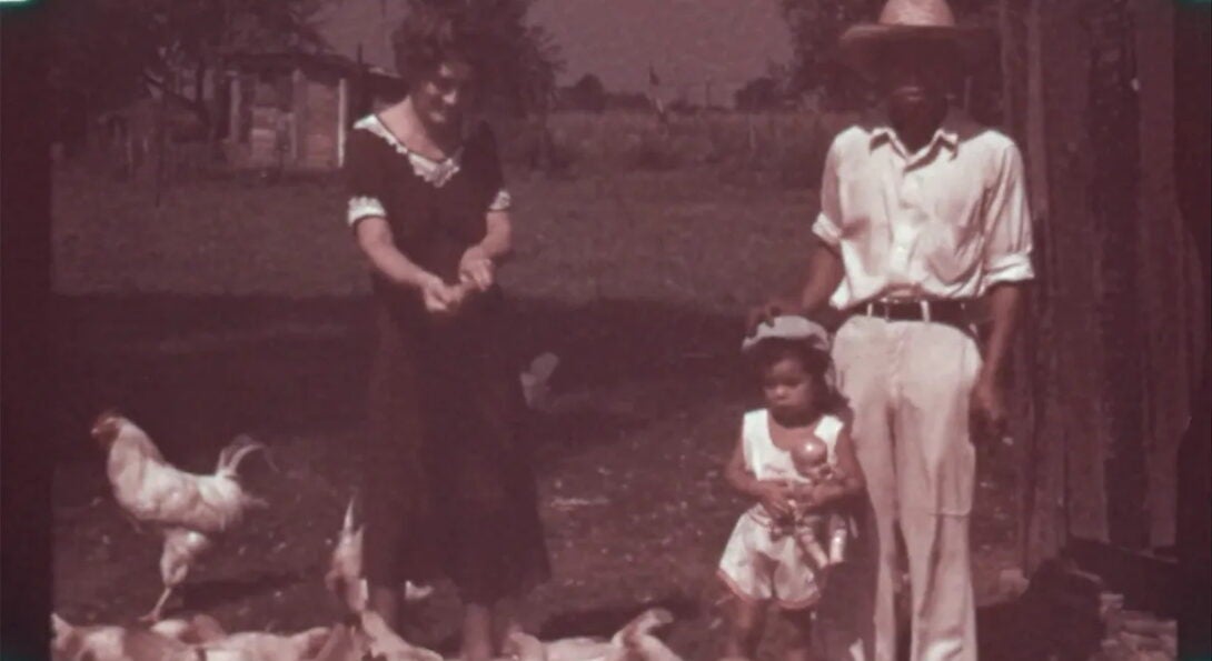 film still of a man, woman, and small child with chickens